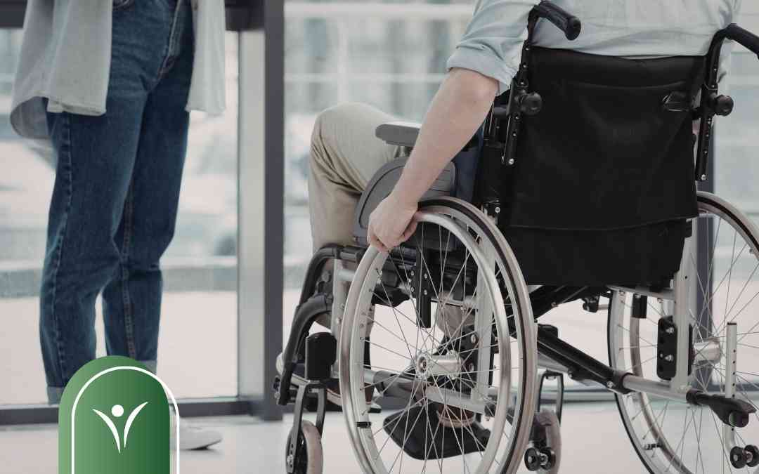 Osoba na wózku inwalidzkim obok opiekuna