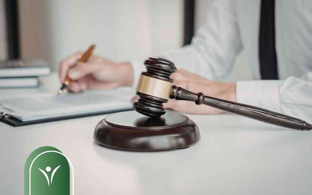 Sędzia podpisuje dokumenty obok drewnianego młotka – symbol procedury odwoławczej do sądu.