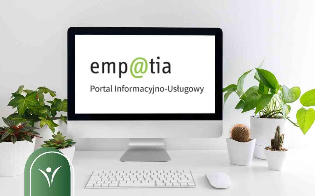 Monitor komputera wyświetlający logo Emp@tia – Portal Informacyjno-Usługowy na jasnym biurku z roślinami doniczkowymi.