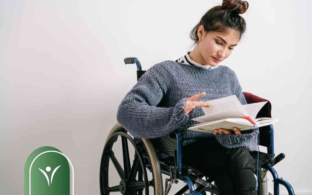 Uśmiechnięta kobieta na wózku inwalidzkim czyta książkę – ilustracja do tematu uzyskiwania wsparcia dla osób niepełnosprawnych.