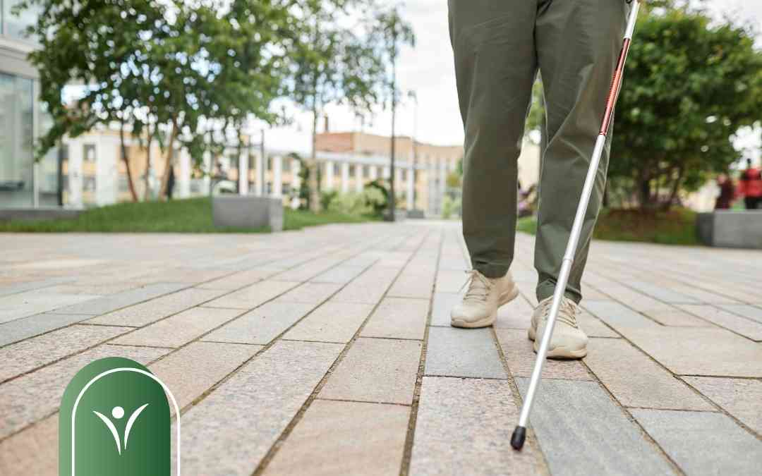 Osoba z niepełnosprawnością idzie chodnikiem, posługując się białą laską – ilustracja do tematu świadczenia wspierającego.