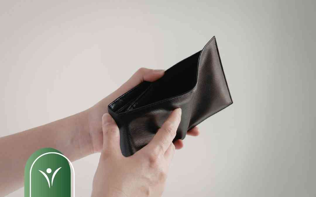 Dłonie trzymające otwarty, pusty portfel jako symbol ryzyka utraty świadczenia wspierającego przez błędy formalne.