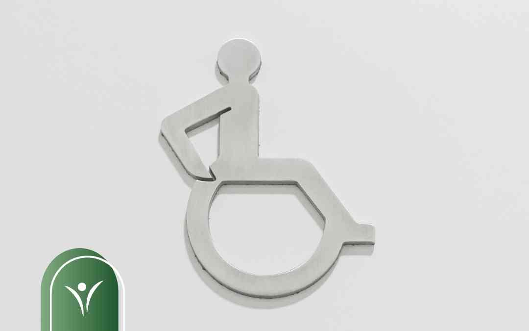 Metalowy piktogram przedstawiający osobę poruszającą się na wózku inwalidzkim.