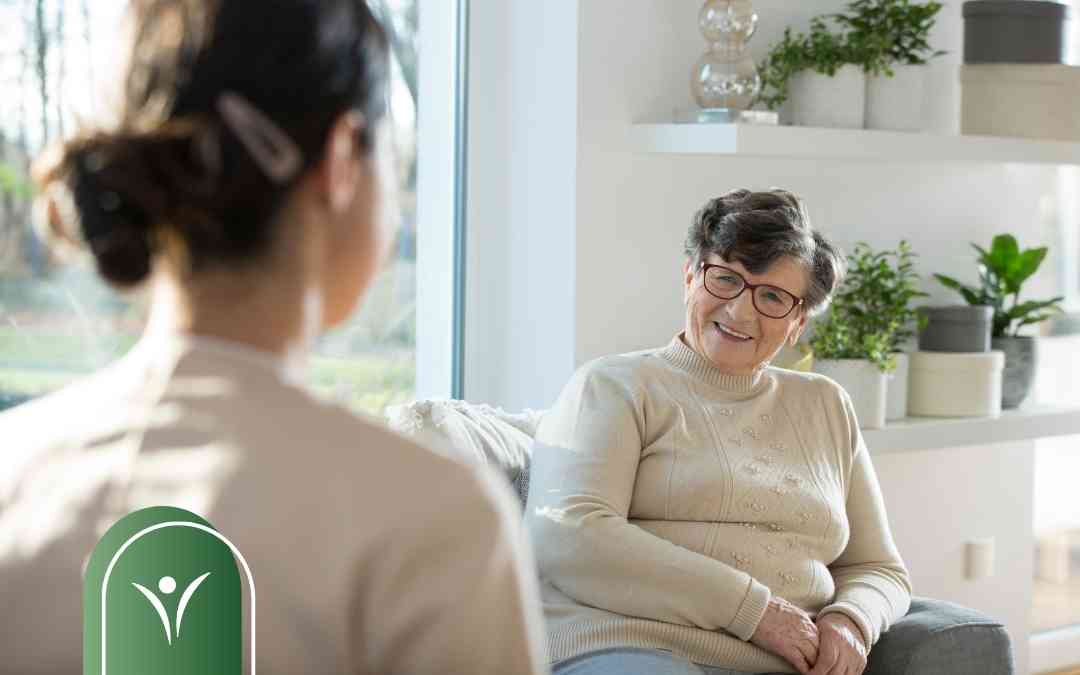 Uśmiechnięta seniorka rozmawia z konsultantem podczas planowania pobytu w sanatorium.